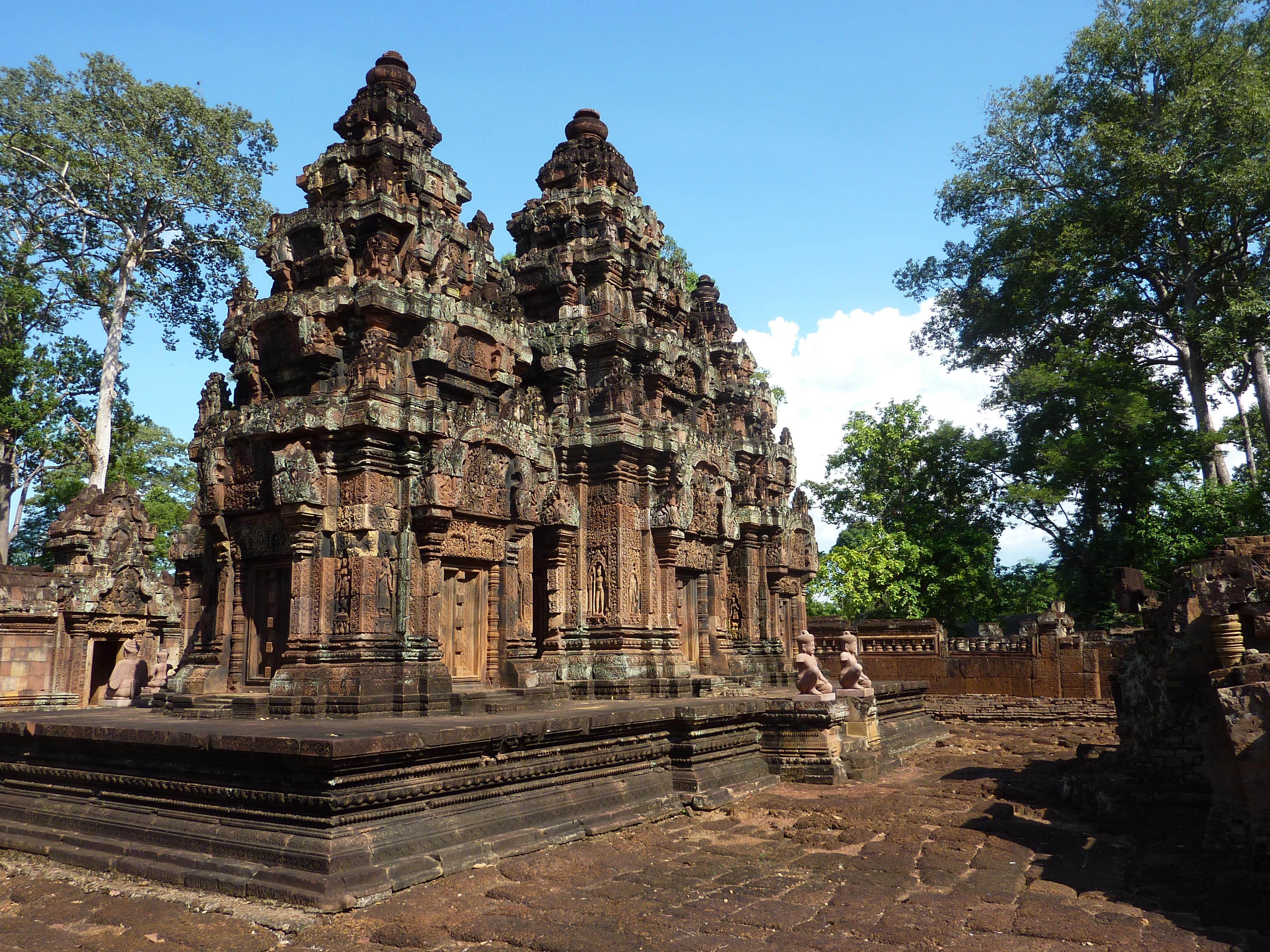 a stone building with many towers with Banteay Srei in the background