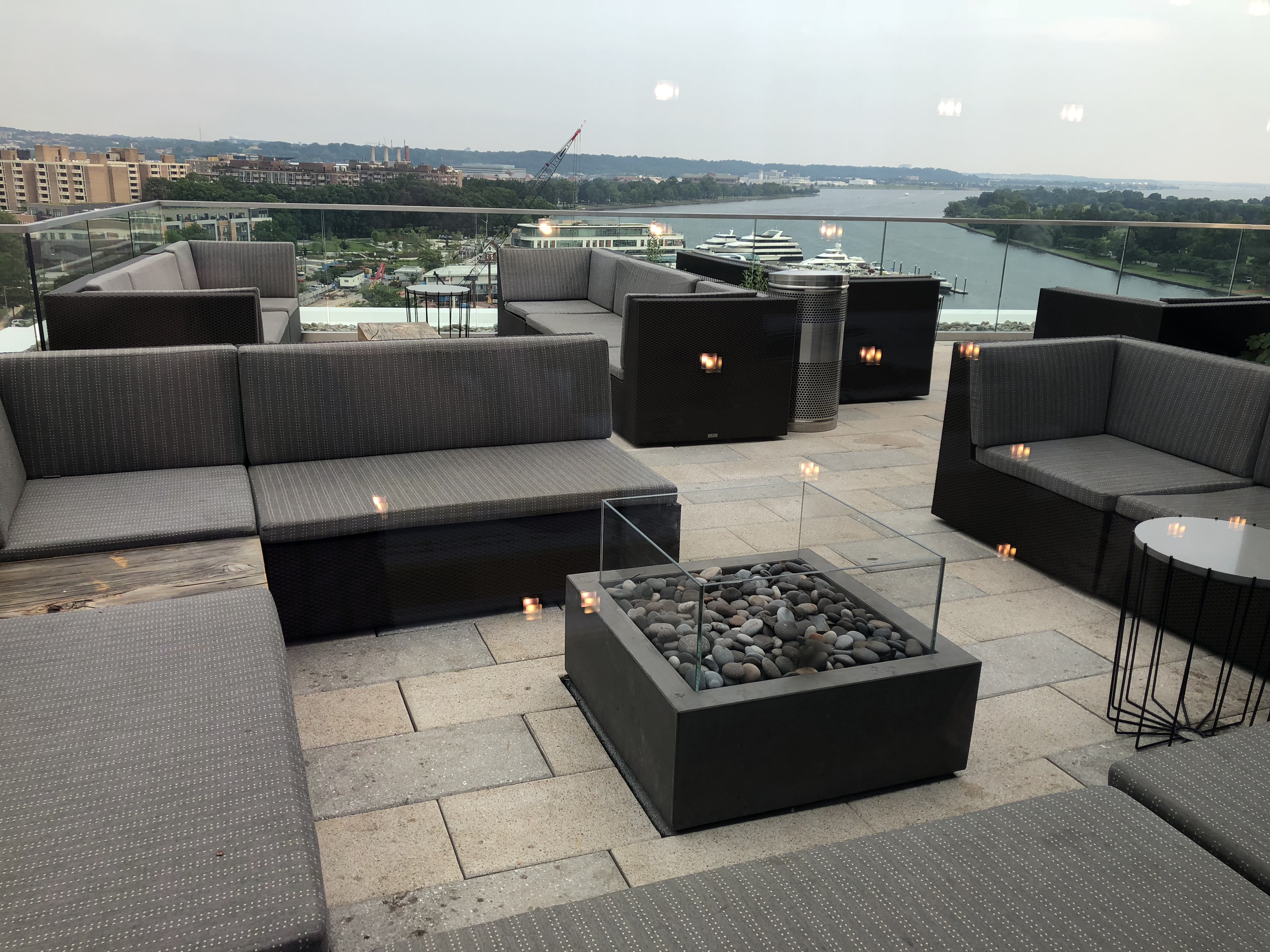 a patio with a fire pit and a city view