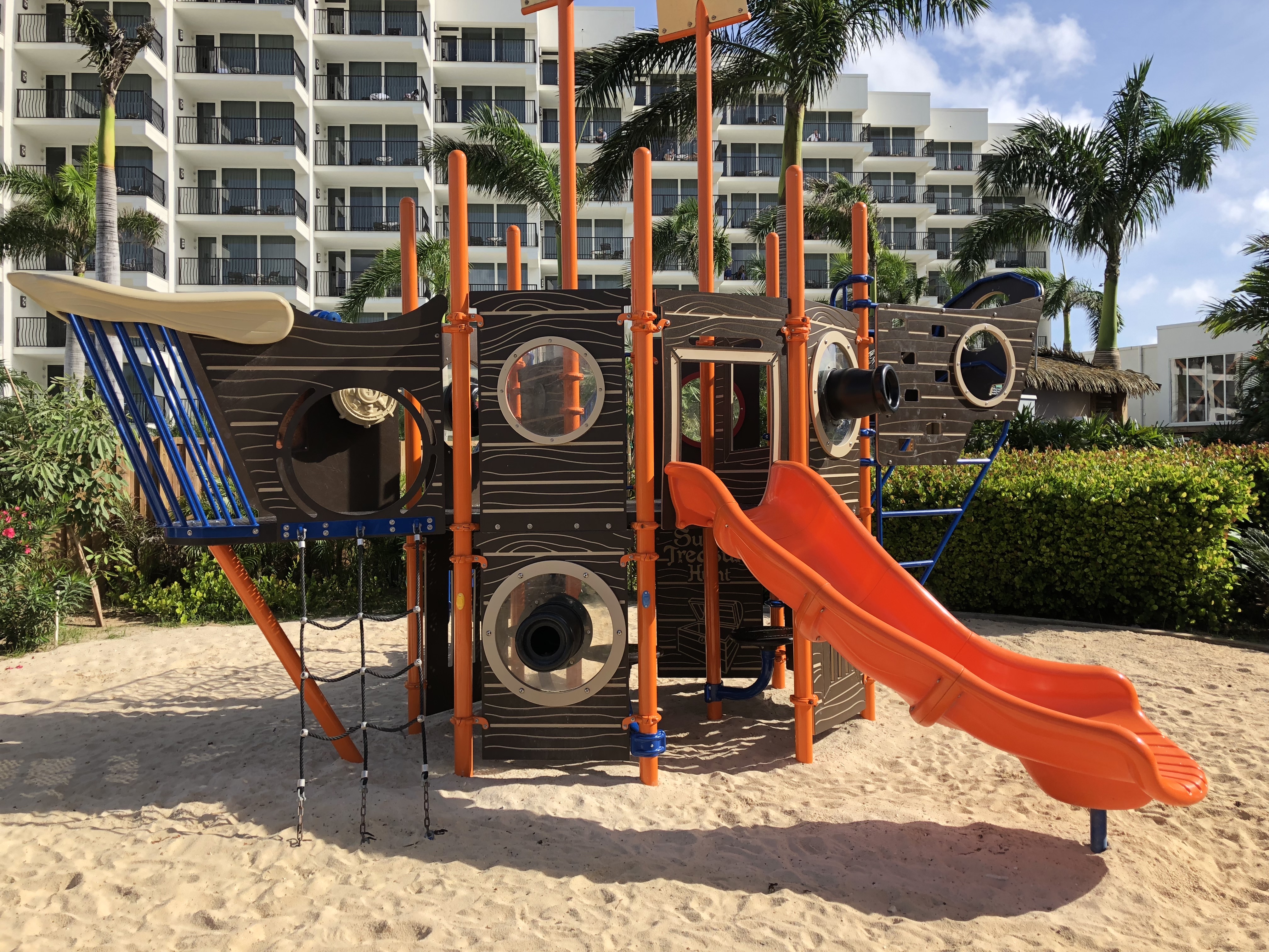 a playground with a slide in the sand