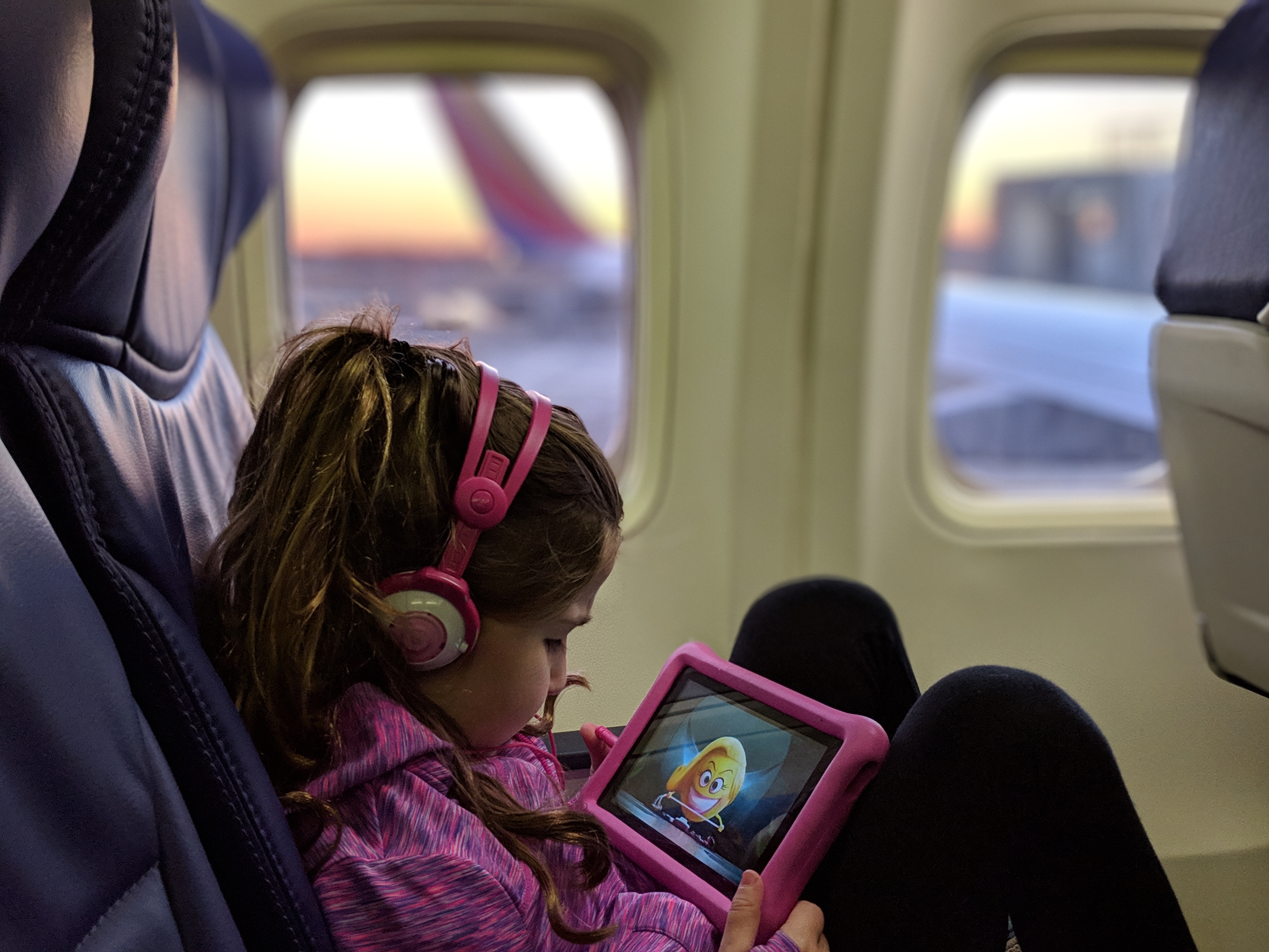 a girl in pink headphones using a tablet