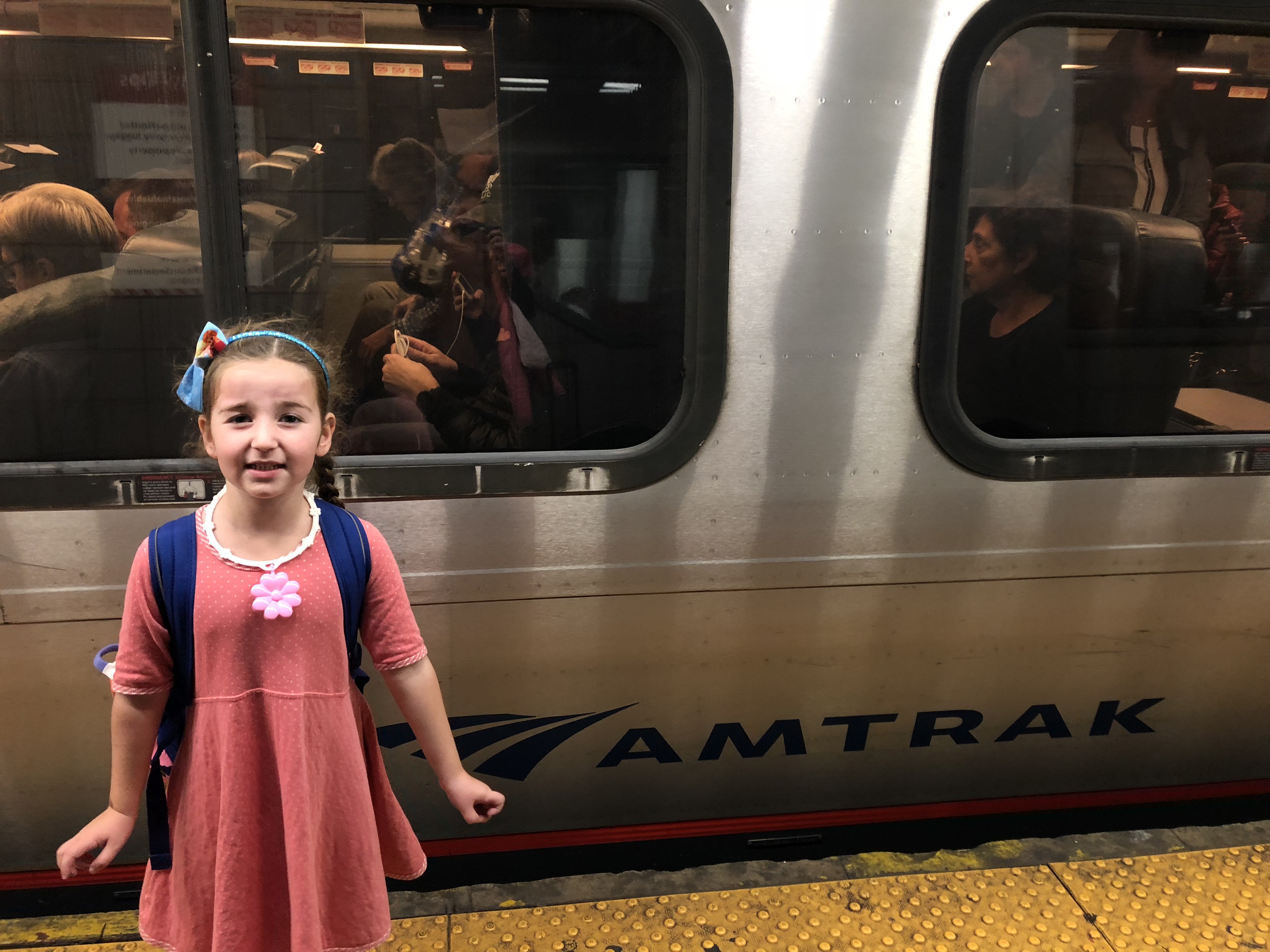 a girl standing in front of a train