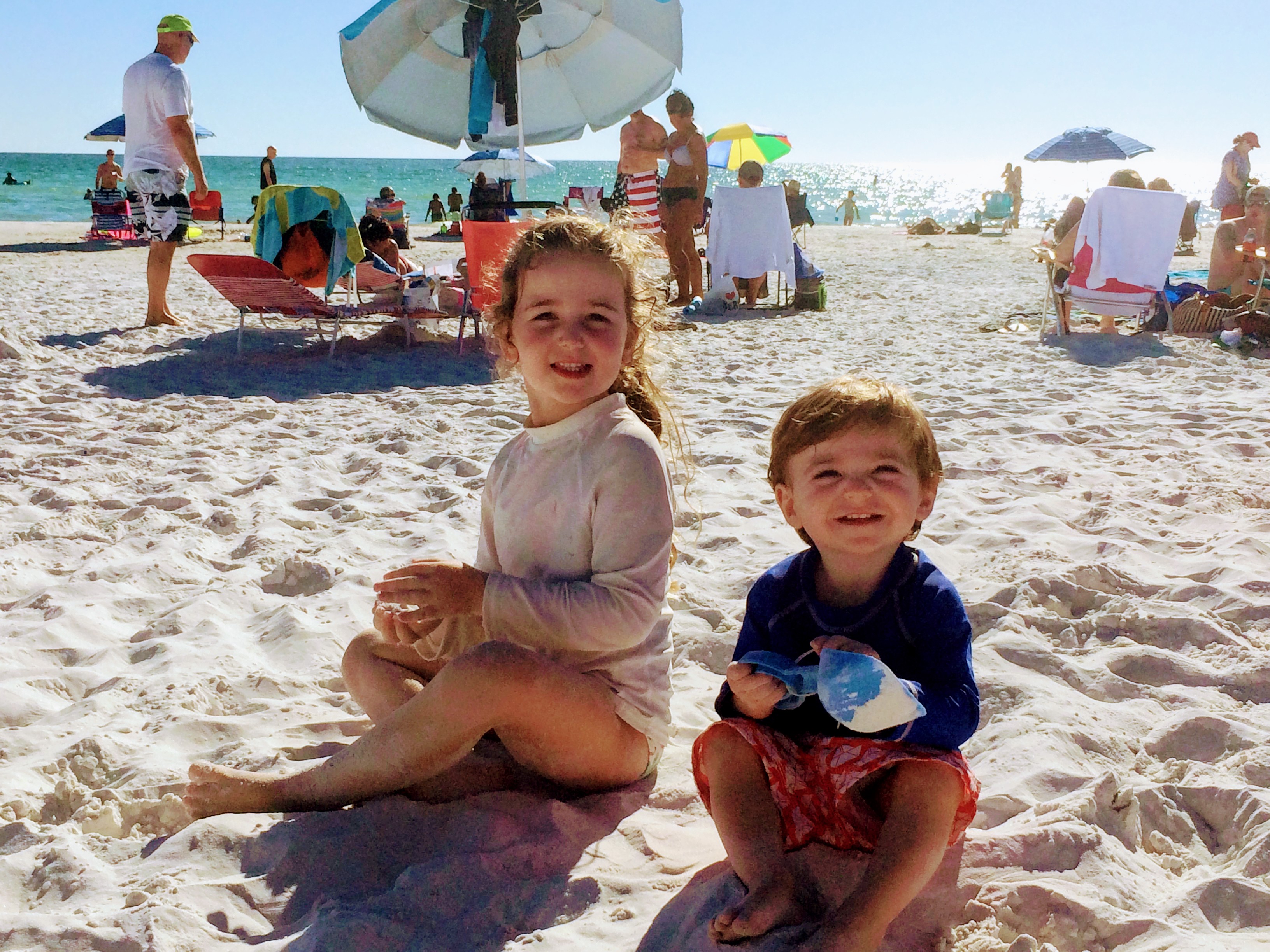 a couple of children sitting on the beach