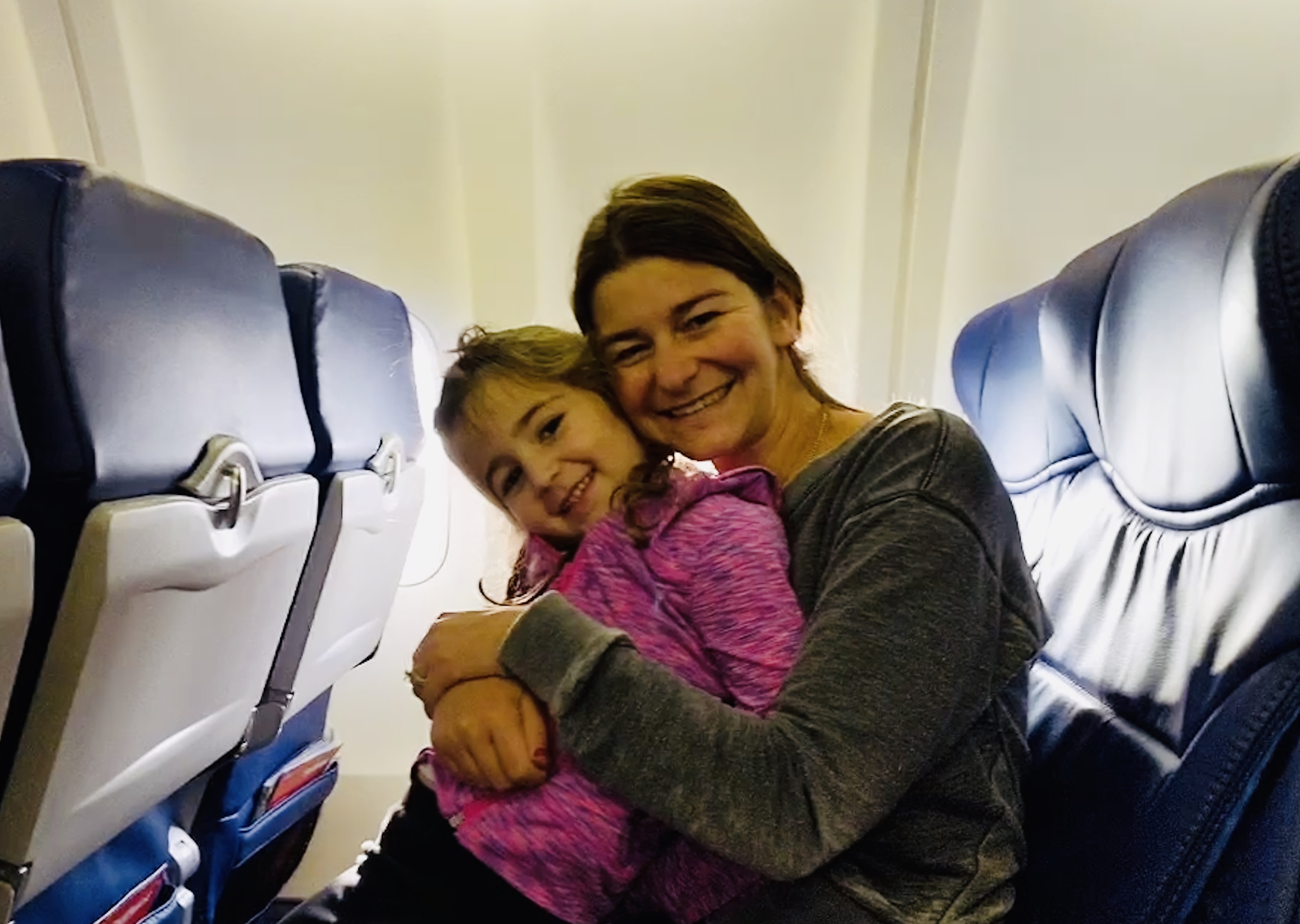 a woman and a child sitting on an airplane