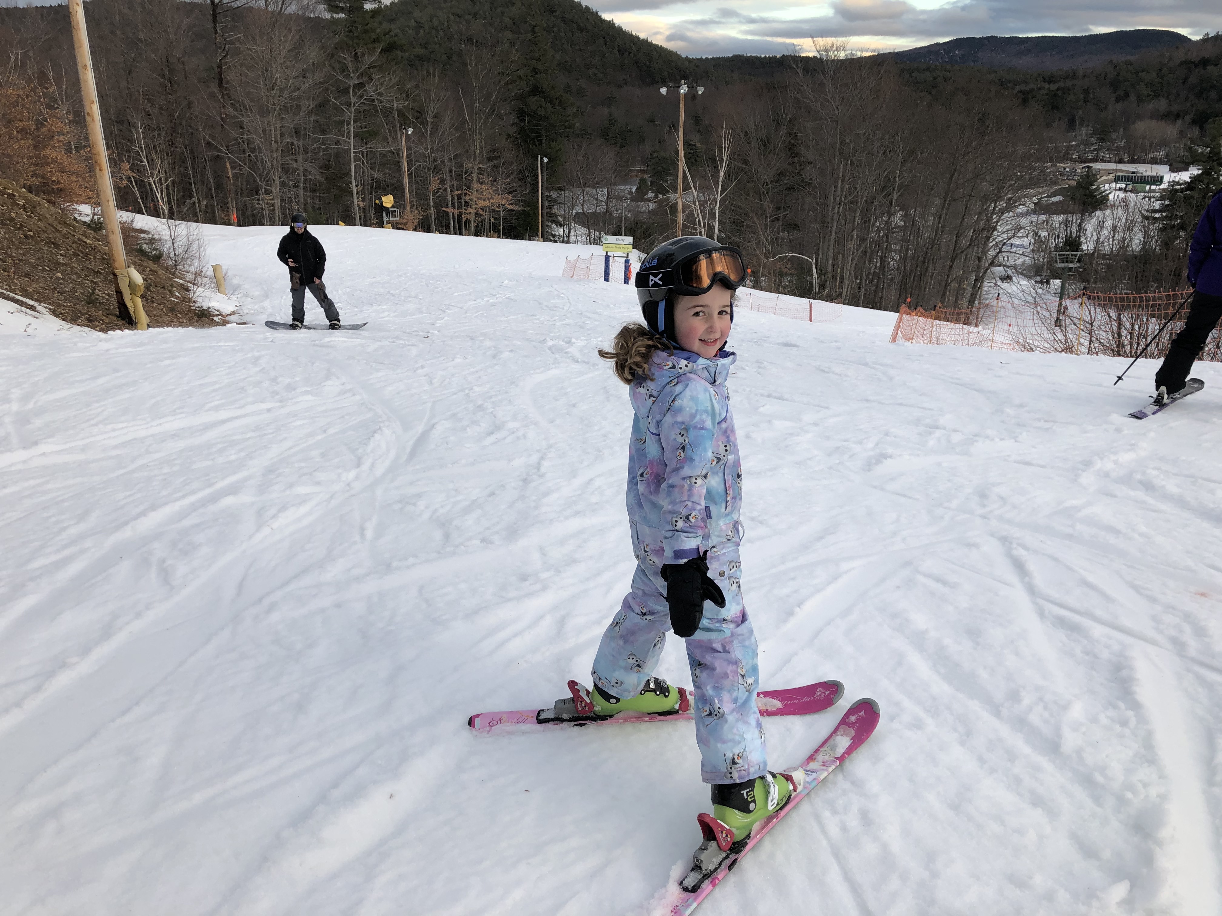 a child on skis on a snowy hill
